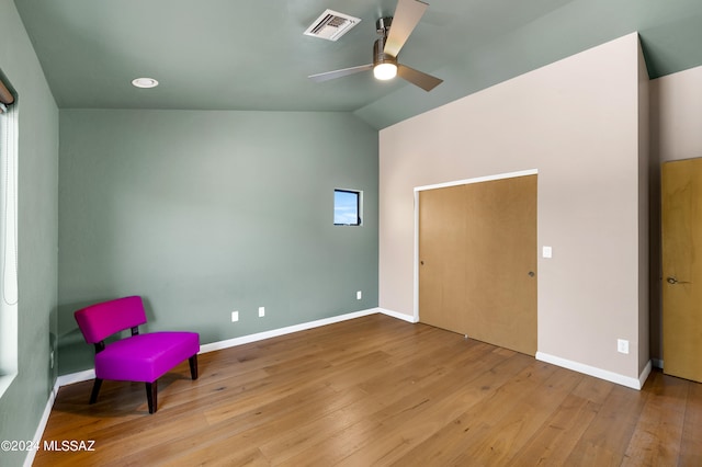 living area with ceiling fan, light wood-type flooring, and vaulted ceiling