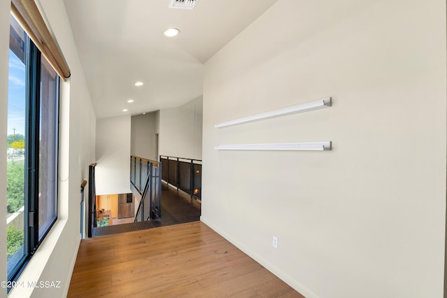 empty room with recessed lighting, visible vents, baseboards, vaulted ceiling, and hardwood / wood-style floors