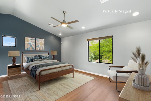 bedroom with baseboards, visible vents, lofted ceiling, ceiling fan, and wood finished floors