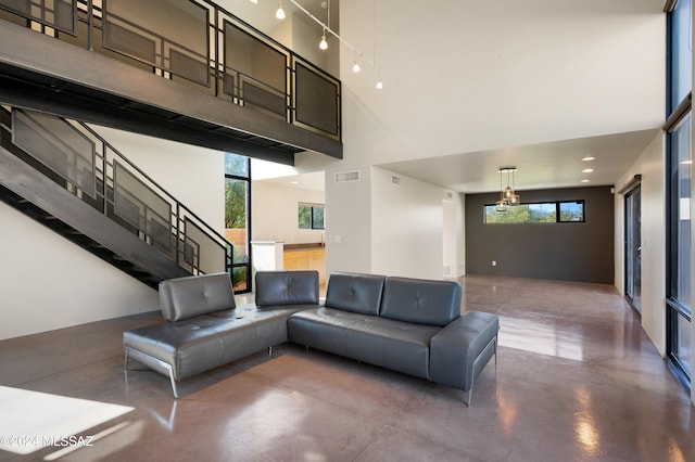 unfurnished living room with concrete flooring and a towering ceiling