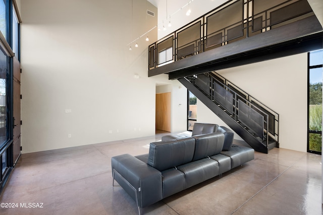 living room featuring a towering ceiling and a wealth of natural light