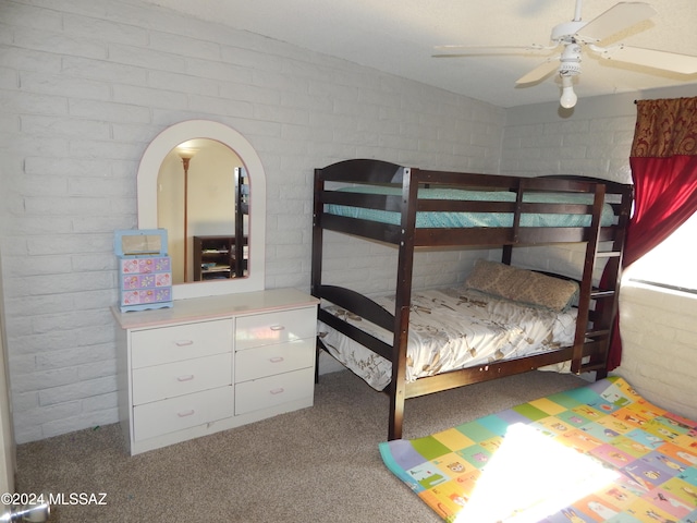 unfurnished bedroom featuring ceiling fan, carpet floors, and brick wall