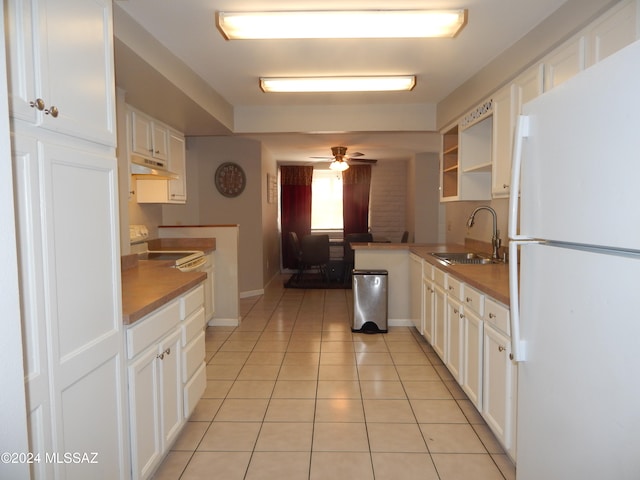 kitchen with white cabinets, sink, ceiling fan, light tile patterned floors, and white fridge