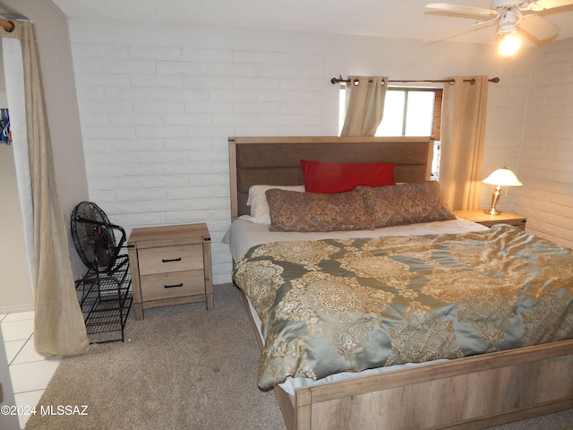 bedroom with ceiling fan, light carpet, and brick wall