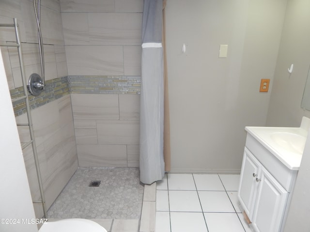 bathroom with tile patterned floors, vanity, and tiled shower