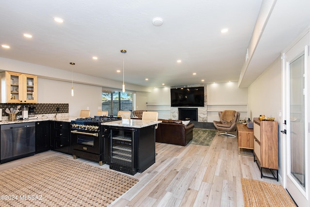 kitchen with dishwasher, double oven range, light hardwood / wood-style flooring, decorative light fixtures, and light stone counters