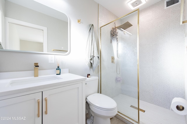 bathroom with a tile shower, vanity, and toilet