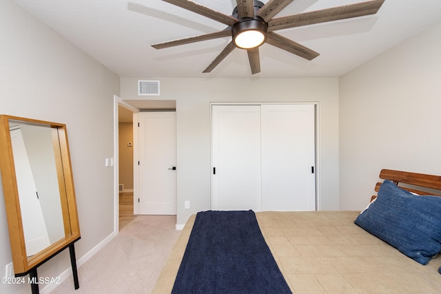 bedroom featuring a closet, ceiling fan, and light colored carpet