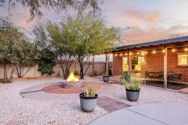 patio terrace at dusk featuring an outdoor fire pit