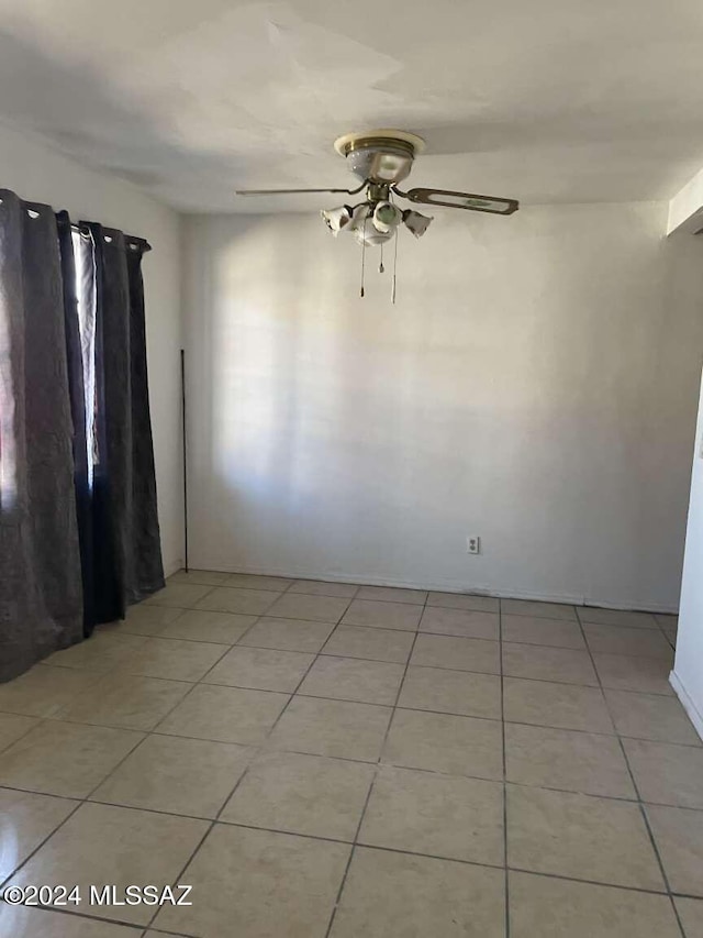 tiled empty room featuring ceiling fan