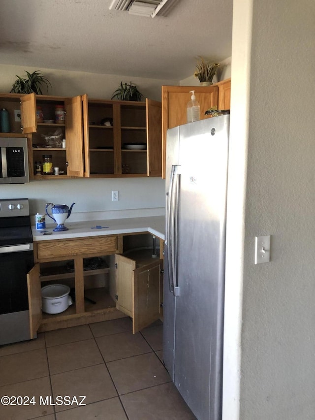 kitchen featuring stainless steel appliances and light tile patterned flooring