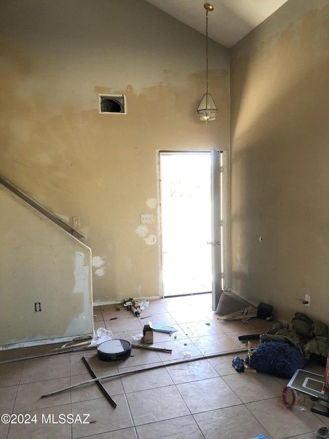 tiled entrance foyer featuring high vaulted ceiling