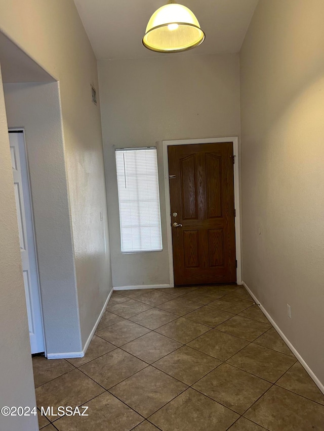 foyer entrance featuring tile patterned flooring and vaulted ceiling