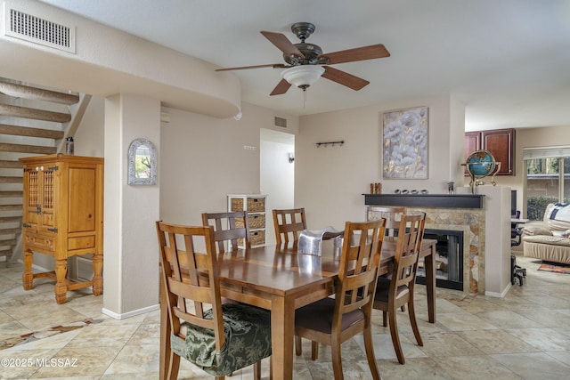 dining room featuring a fireplace and ceiling fan