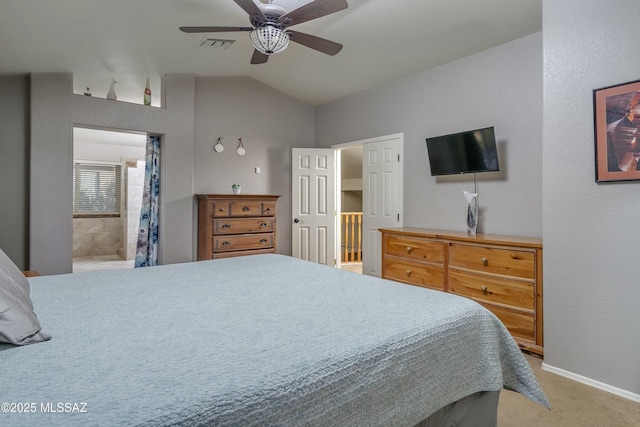 carpeted bedroom featuring ceiling fan, vaulted ceiling, and ensuite bath