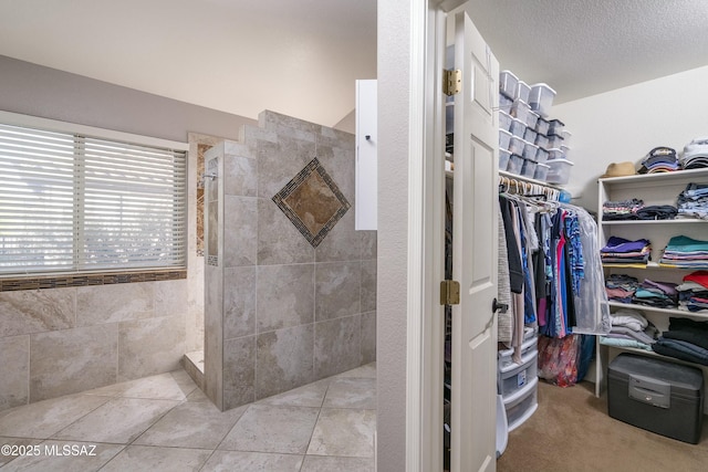 bathroom featuring a tile shower and tile patterned flooring