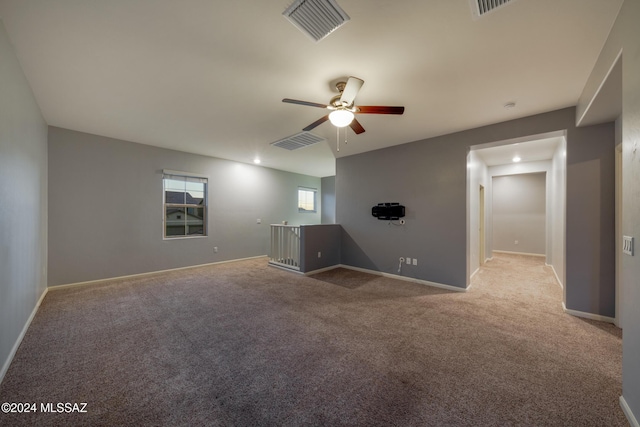 carpeted spare room featuring ceiling fan