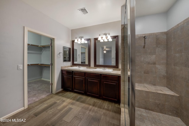 bathroom with hardwood / wood-style flooring, vanity, and an enclosed shower