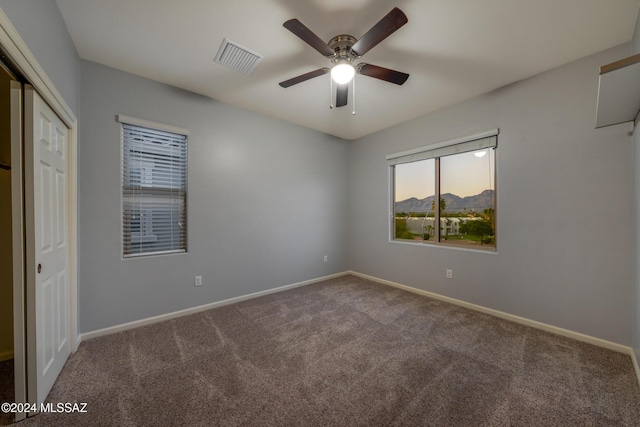 unfurnished bedroom featuring carpet flooring, a closet, and ceiling fan