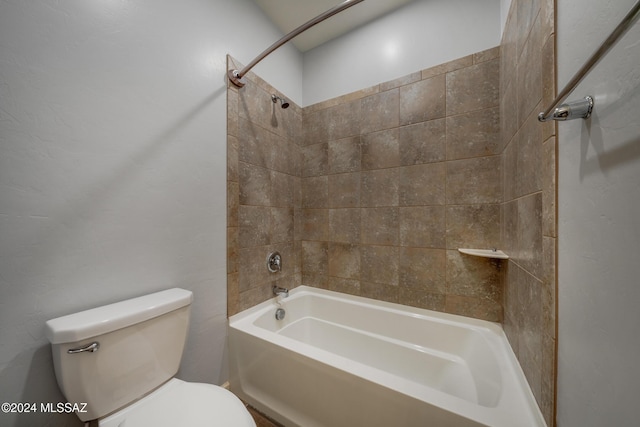 bathroom featuring toilet and tiled shower / bath