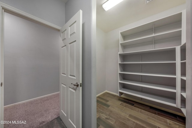 walk in closet with dark hardwood / wood-style flooring