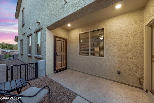 exterior entry at dusk featuring a patio