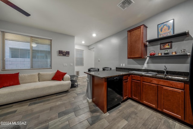 kitchen featuring sink, black dishwasher, kitchen peninsula, dark stone countertops, and hardwood / wood-style floors