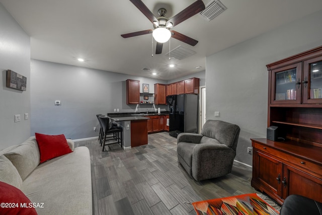 living room featuring dark hardwood / wood-style floors, ceiling fan, and sink