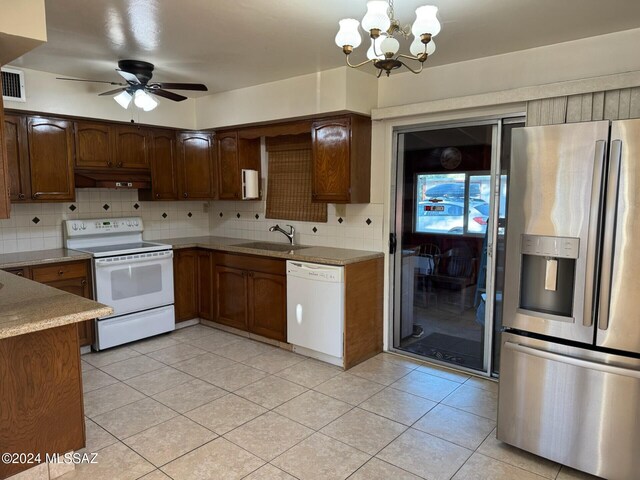 kitchen featuring white appliances, backsplash, ceiling fan with notable chandelier, sink, and light tile patterned floors