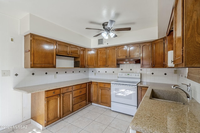 kitchen with backsplash, sink, ceiling fan, light stone counters, and range