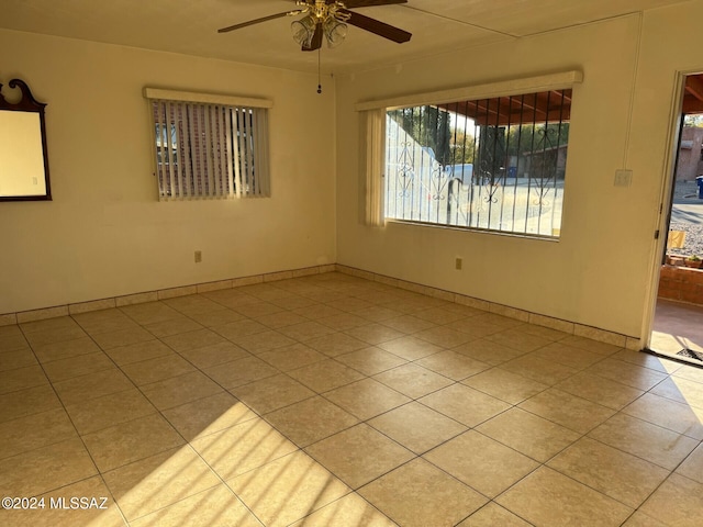 tiled spare room featuring ceiling fan