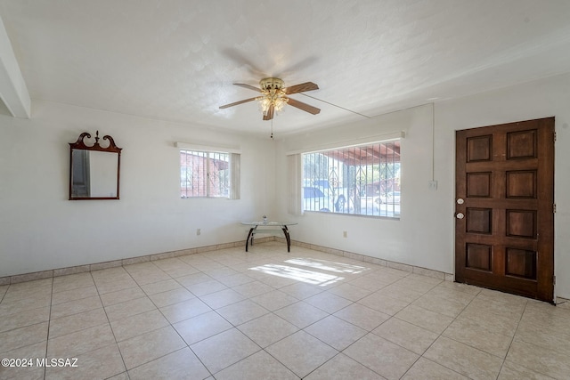 entryway with ceiling fan, a healthy amount of sunlight, and light tile patterned floors