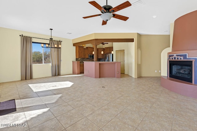 unfurnished living room with ceiling fan with notable chandelier and light tile patterned floors