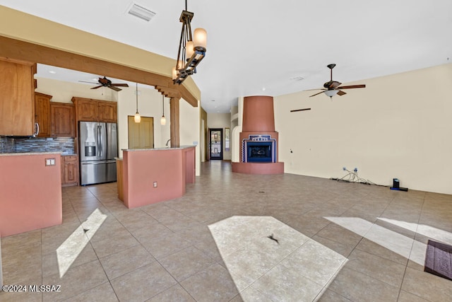 kitchen with backsplash, decorative light fixtures, light tile patterned floors, and stainless steel refrigerator with ice dispenser