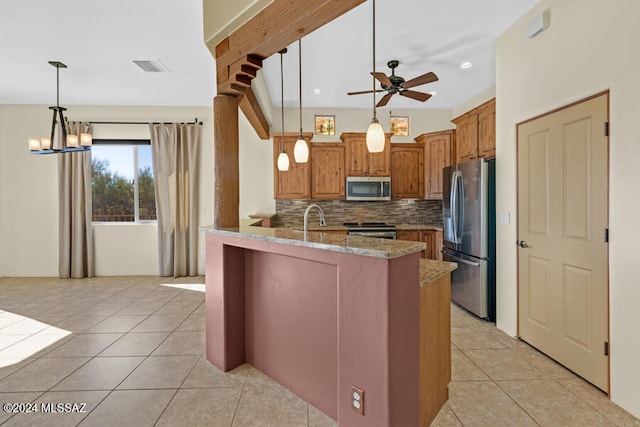 kitchen featuring light tile patterned floors, tasteful backsplash, decorative light fixtures, kitchen peninsula, and stainless steel appliances