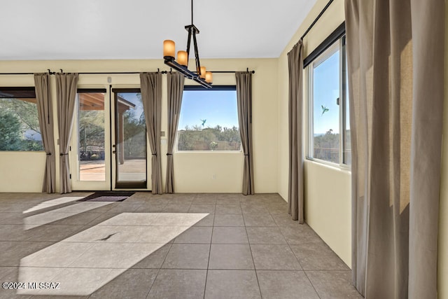 doorway featuring light tile patterned floors and an inviting chandelier