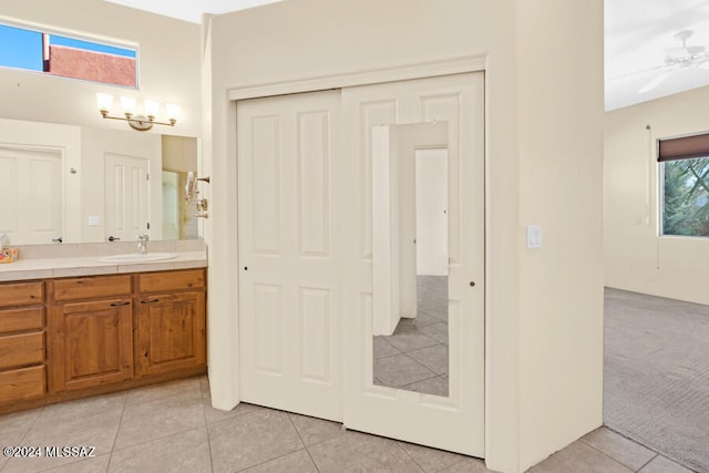 bathroom with tile patterned floors, ceiling fan with notable chandelier, and vanity