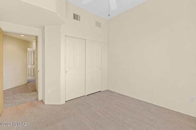 unfurnished bedroom featuring ceiling fan and a closet