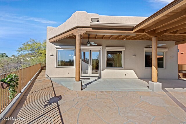 rear view of property featuring ceiling fan and a patio area