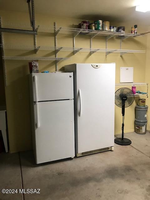 interior space featuring white fridge and concrete floors