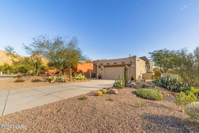 pueblo-style house featuring a garage