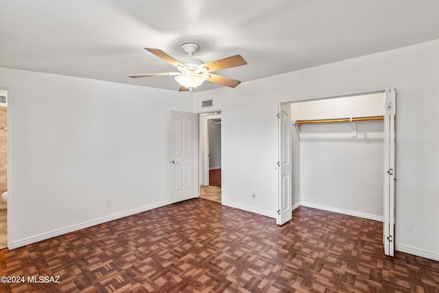 unfurnished bedroom featuring a closet, ceiling fan, dark parquet floors, and ensuite bath