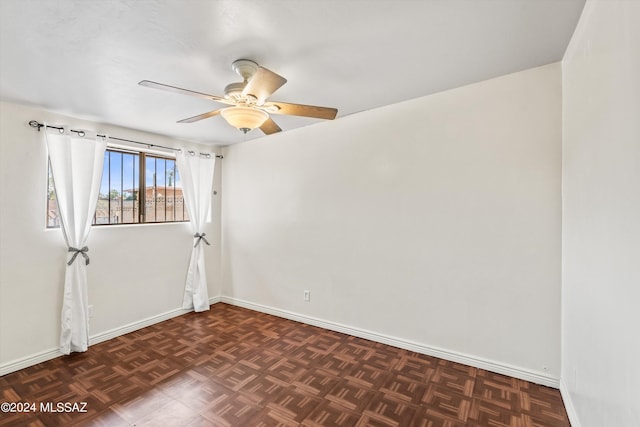 unfurnished room featuring dark parquet flooring and ceiling fan