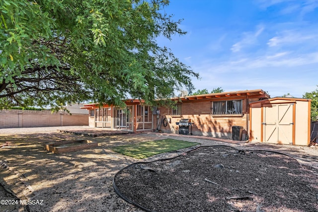 back of house featuring a storage unit