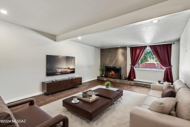 living room with beam ceiling, light hardwood / wood-style floors, and a fireplace