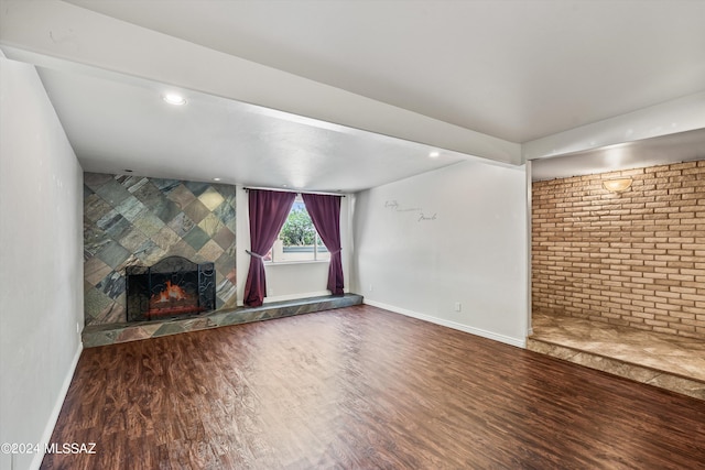 unfurnished living room featuring a tile fireplace and hardwood / wood-style floors