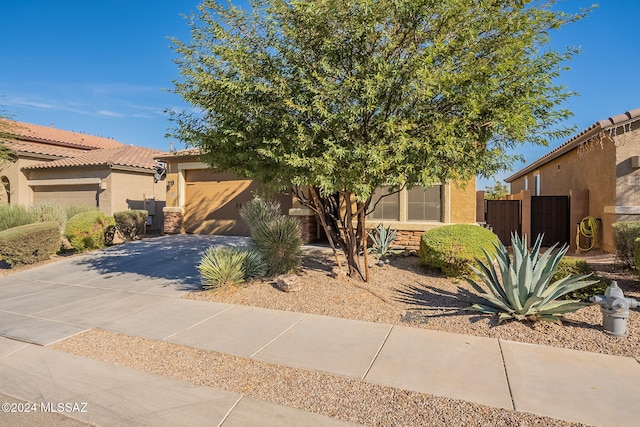 6551 E Via Arroyo Largo, Tucson, AZ 85756 - obstructed view of property with driveway, an attached garage, and stucco siding
