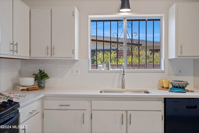 kitchen with backsplash, dishwasher, white cabinetry, and sink