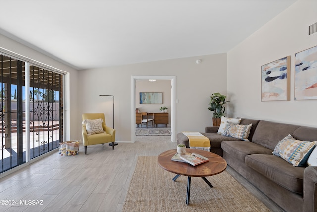 living room featuring lofted ceiling and light wood-type flooring