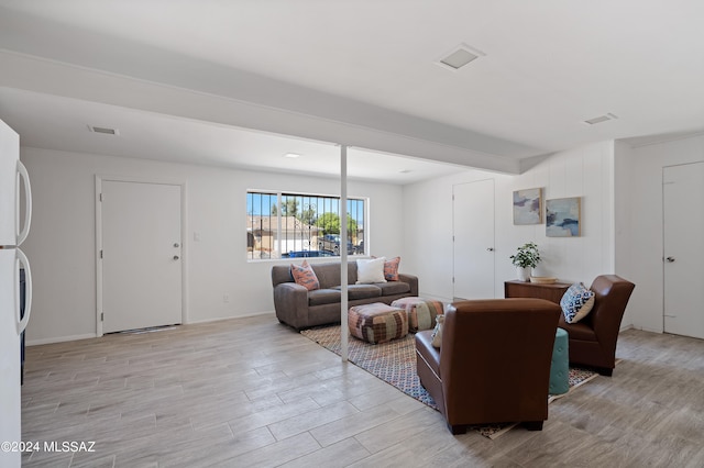 living room with beam ceiling and light wood-type flooring